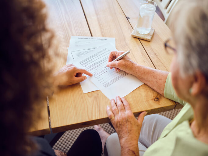 Older woman signing estate planning documents